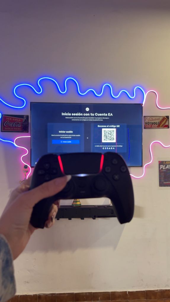 Pantalla con PlayStation 5 y joystick en mano, rodeada de neón