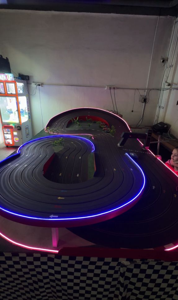 Pista de Scalextric iluminada con neón azul y rosa